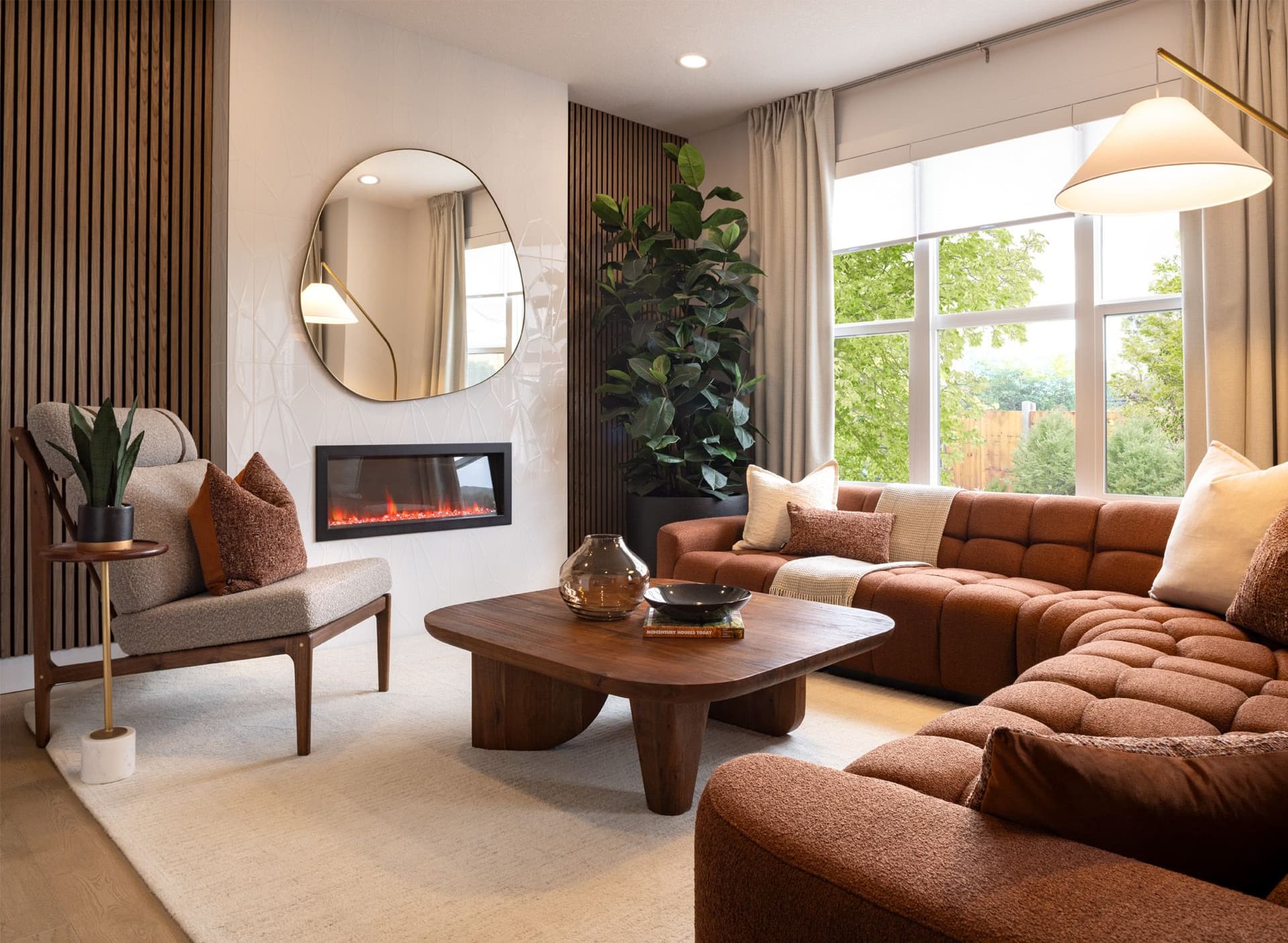 The Sawgrass Park Carisa's living room with a cozy fireplace, unique accent wall and large window.